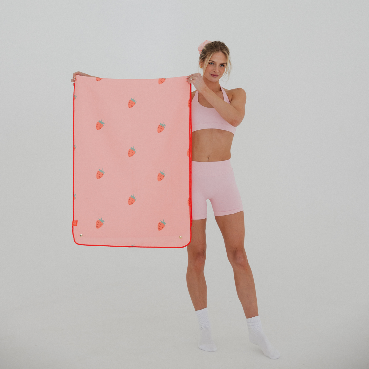 model holding pink yoga mat towel with strawberry print