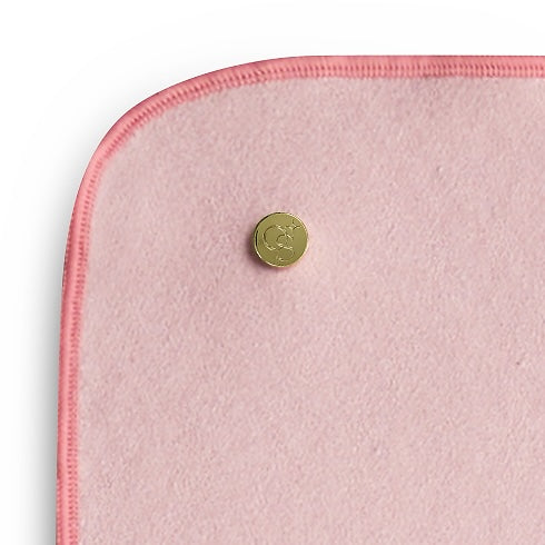 close up corner of pink yoga mat towel with gold button
