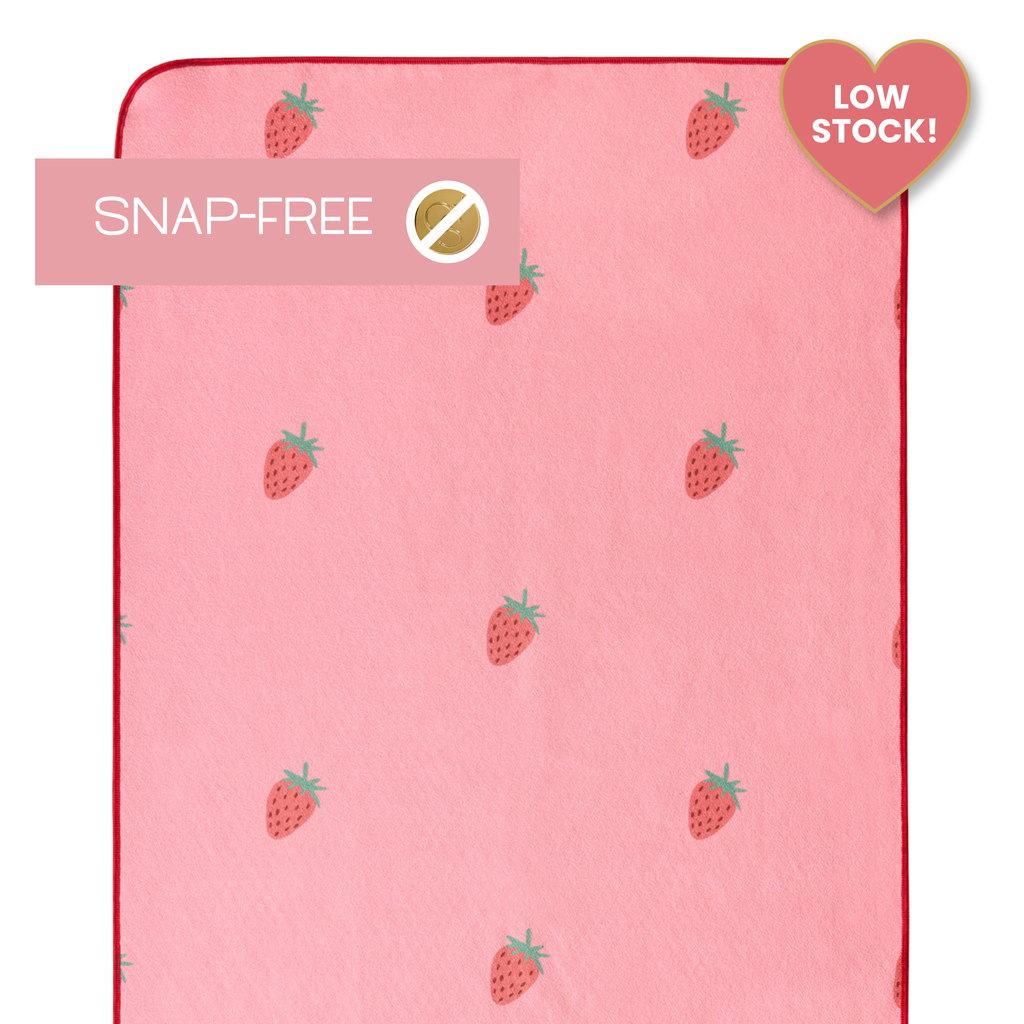 pink yoga mat towel with strawberries and labels that say "snap-free" and "low stock"