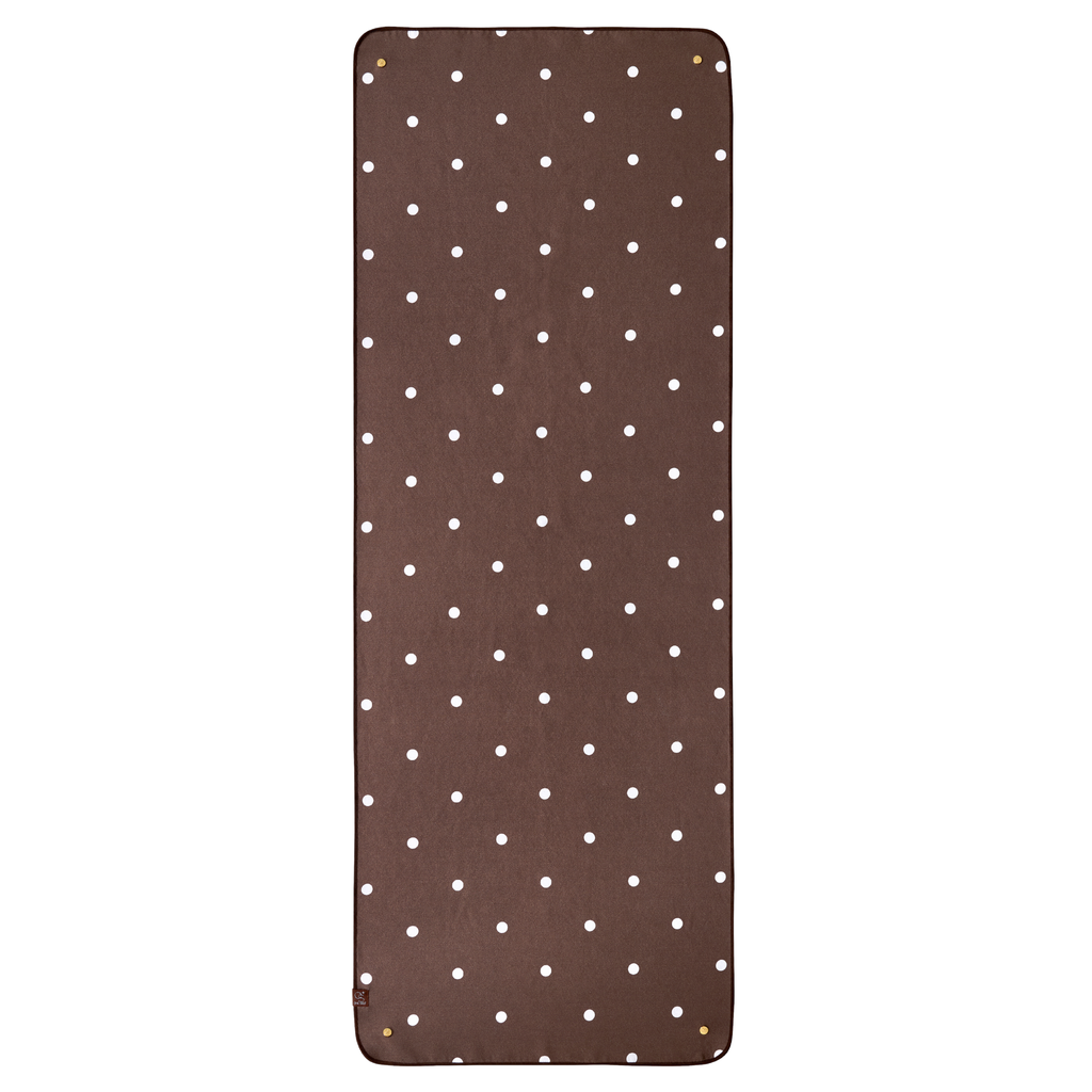 Dark brown yoga mat towel with white polka dots and gold buttons. 