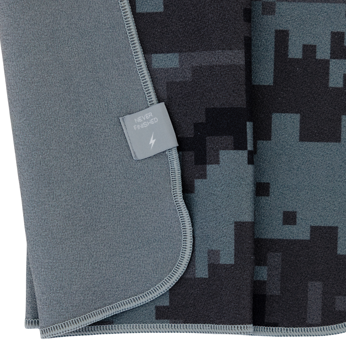 Gray towel with digital camouflage pattern and a brand tag on a white background