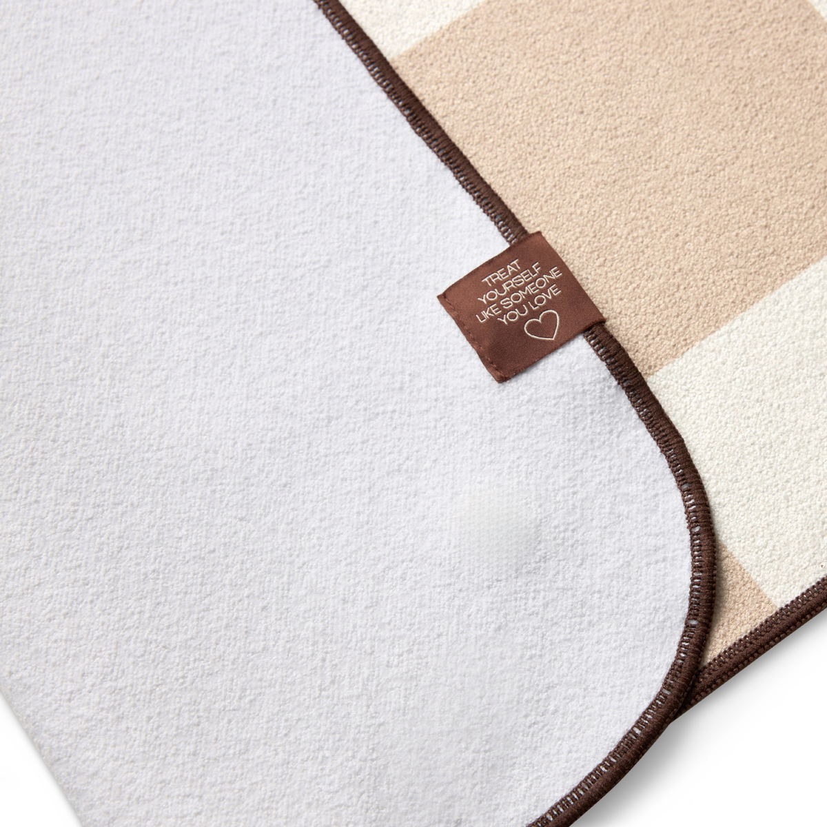checkered yoga mat towel with brown border folded to show white on back